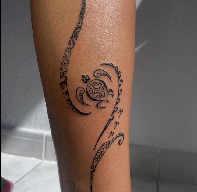 Tatouage tribal polynésien sur mollet — tortue stylisée et motifs géométriques